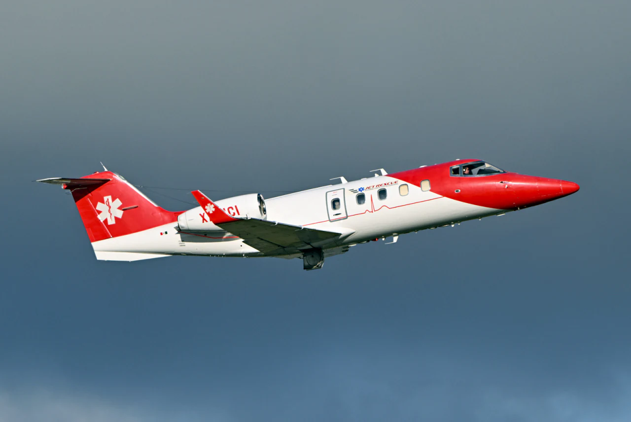 A medevac jet climbing against storm clouds
