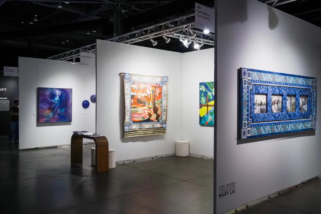 An art fair booth hung with contemporary works