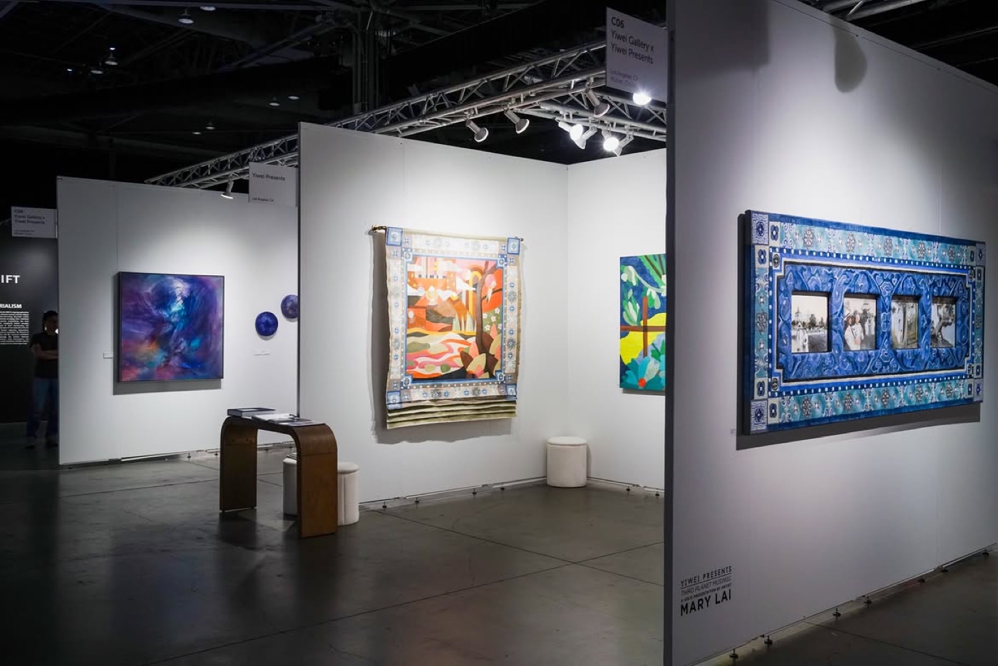 An art fair booth hung with contemporary works