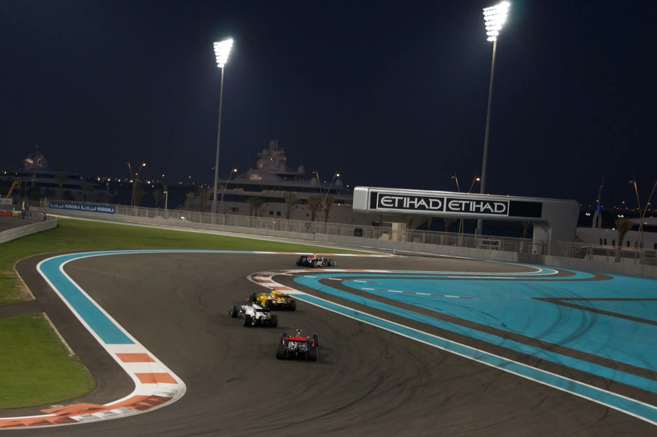 Formula 1 cars racing under floodlights at Yas Marina