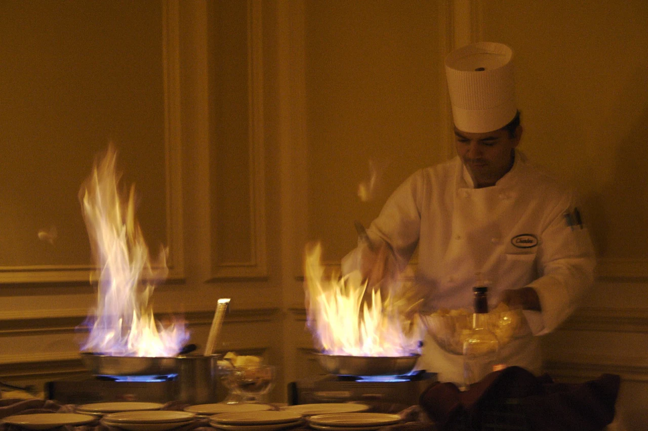 A chef flambéing at a private dinner